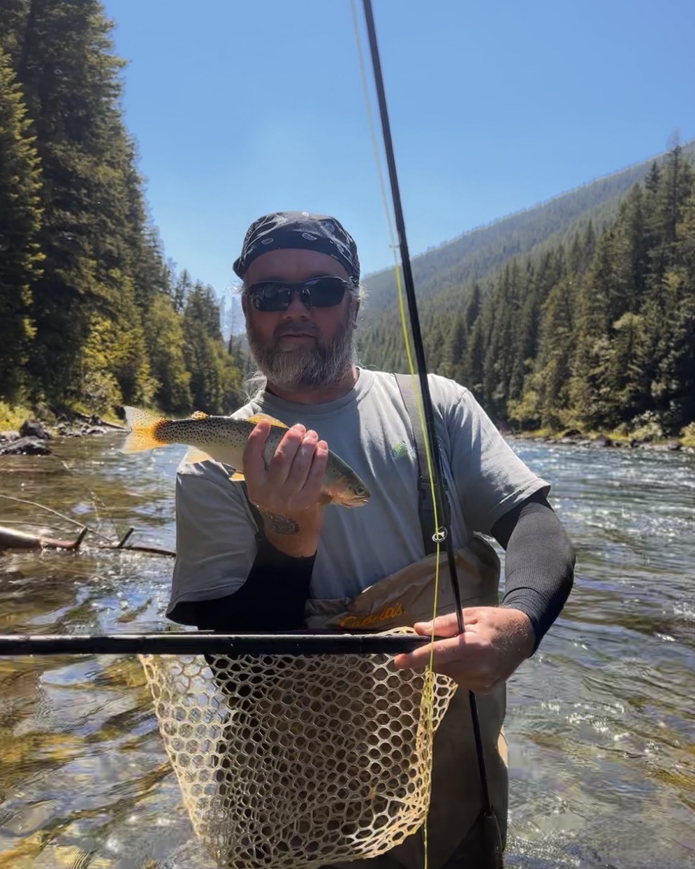 Randy in a Montana river holding a trout